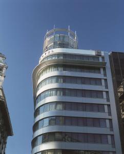 een hoog glazen gebouw met een blauwe lucht op de achtergrond bij NH Buenos Aires Latino in Buenos Aires