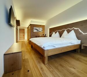 a bedroom with a large bed with a wooden headboard at Hotel Panorama in Hasliberg