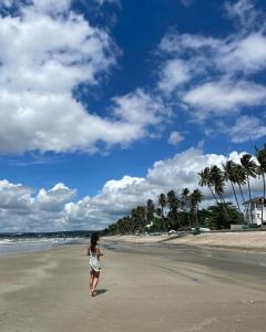 uma mulher andando na praia com um papagaio em Lang Chai Guesthouse em Mui Ne