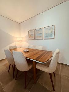 een eetkamer met een houten tafel en stoelen bij M&E Premium Apartments - San Pietro in Durrës