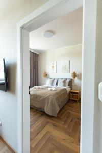 1 dormitorio con 1 cama y suelo de madera en Apartamenty Rynek 12, en Tarnów