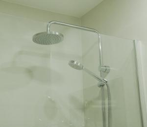 ducha con puerta de cristal y cabezal de ducha en Hotel Verol, en Las Palmas de Gran Canaria