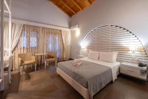 a bedroom with a bed and a table and chairs at Aktaion Resort in Gythio