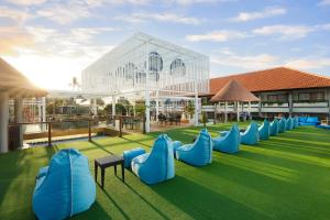 a row of blue chairs on a green lawn at Bali Dynasty Resort in Kuta