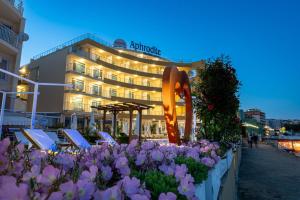 un hotel con sedie e fiori di fronte di Aphrodite Beach Hotel a Nesebar