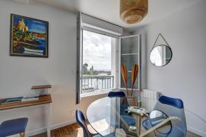 ブレストにあるAppartement neuf - Vue sur la mer et la Tour Tanguyのガラスのテーブルと椅子、窓が備わる客室です。