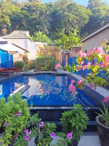 una piscina con fiori in un cortile di Family Garden Homestay a Senggigi