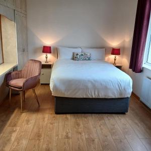 ein Schlafzimmer mit einem Bett, zwei Lampen und einem Stuhl in der Unterkunft Green Acres Self Catering in Claremorris