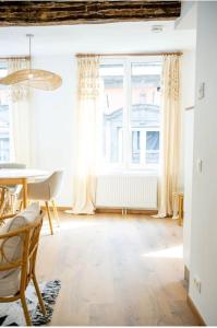 ein Wohnzimmer mit einem Tisch und einem Fenster in der Unterkunft Suite26-2 in Namur