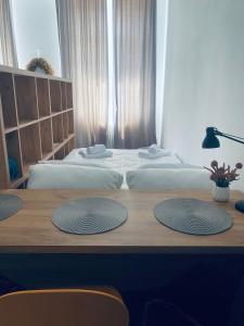 um quarto com 2 camas e uma mesa de madeira em Apartment Center Zilina near Train and Bus station em Žilina