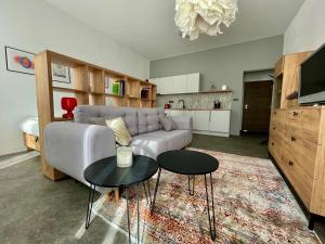 uma sala de estar com um sofá e duas mesas em Apartment Center Zilina near Train and Bus station em Žilina