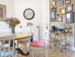 une salle à manger avec une table et une horloge murale dans l'établissement Church Path, à Emsworth