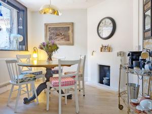 une salle à manger avec une table, des chaises et une cheminée dans l'établissement Church Path, à Emsworth