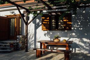 une table de pique-nique et un banc devant un bâtiment dans l'établissement Karaiskos Agritourism Farm, à Portariá