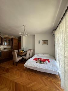 a bedroom with a bed and a table with chairs at City Heart Apartments in Ulcinj