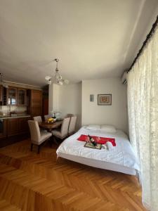 a bedroom with a bed and a table with chairs at City Heart Apartments in Ulcinj