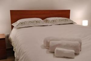 a large white bed with two pillows on it at Casa Neto Jardim in Calheta