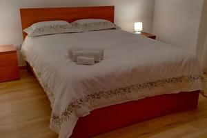 a bedroom with a large bed with two pillows at Casa Neto Jardim in Calheta