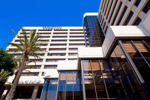 ein hohes Gebäude mit einer Palme davor in der Unterkunft The Westin Los Angeles Airport in Los Angeles