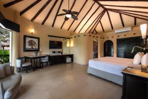 a bedroom with a bed and a desk in a room at El Dorado Casitas Royale Catamarán, Cenote & More Inclusive in Puerto Morelos