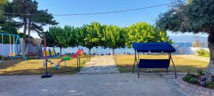 un parque con un parque infantil con sillas y árboles en Senia Holidays, en Preveza