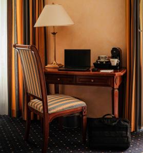 una scrivania con lampada e computer portatile di Grand Hotel et Centre Thermal d'Yverdon-les-Bains a Yverdon-les-Bains