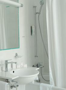 bagno bianco con lavandino e doccia di Grand Hotel et Centre Thermal d'Yverdon-les-Bains a Yverdon-les-Bains