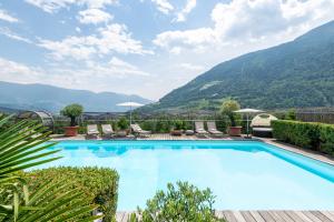 une piscine avec des montagnes en arrière-plan dans l'établissement Hotel Residence MaVie, à Lagundo