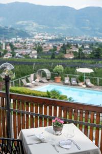 - une table sur un balcon avec vue sur la piscine dans l'établissement Hotel Residence MaVie, à Lagundo