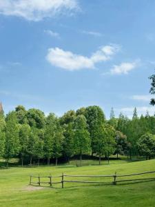 a fence in a field with trees in the background at Crowne Plaza Chengdu Panda Garden, an IHG Hotel in Chengdu