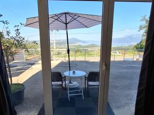 a patio door with a table and an umbrella at Guest house Vila Vedesa in Kotor