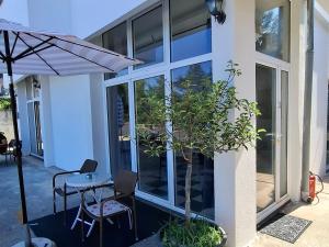 a patio with a table and chairs and an umbrella at Guest house Vila Vedesa in Kotor