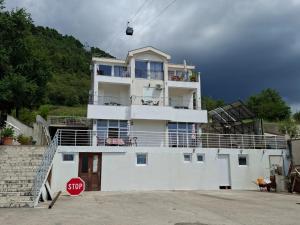 a white building with a balcony and a stop sign at Guest house Vila Vedesa in Kotor