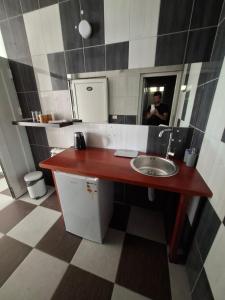 a man taking a picture of a bathroom with a sink at Guest house Vila Vedesa in Kotor