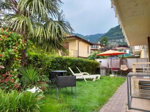 a yard with chairs and a table and an umbrella at Casa Lisa in Lenno