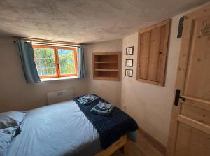 una camera da letto con un letto con una coperta blu e una finestra di Studio duplex en face Les Arcs a Bourg-Saint-Maurice