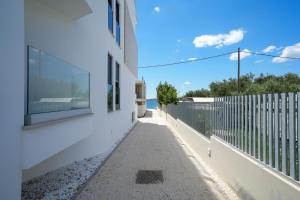 un bâtiment blanc avec une fenêtre et un trottoir dans l'établissement DʻArt Villa, à Bibinje