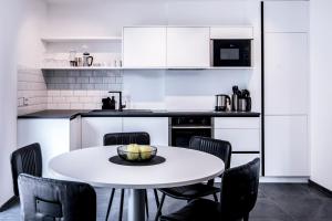 a kitchen with a white table and chairs at Apartmenthouse STERN in Vipiteno