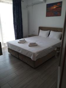 a bedroom with a bed with two towels on it at Vila Ame Eforie Nord in Eforie Nord