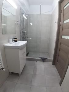 a white bathroom with a shower and a sink at Vila Ame Eforie Nord in Eforie Nord