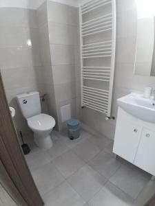 a white bathroom with a toilet and a sink at Vila Ame Eforie Nord in Eforie Nord