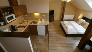 a bathroom with a bed and a sink in a room at Gellény Lux Apartman in Gyula