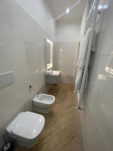 bagno bianco con servizi igienici e lavandino di Casa Maiorino a Torre del Greco