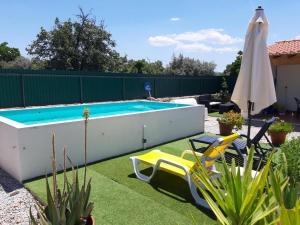 uma piscina num quintal com duas cadeiras e um guarda-sol em Casas de Marvão - Casa do Ribeiro em Marvão