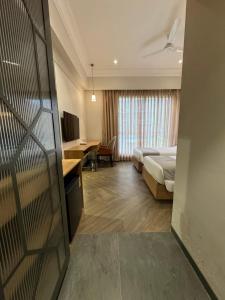 Hotel Mumbai House Mindspace Malad في مومباي: غرفة في الفندق مع سرير ومكتب