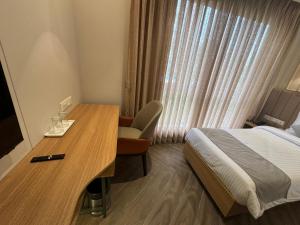 Hotel Mumbai House Mindspace Malad في مومباي: فندق غرفه بسرير ومكتب وسرير