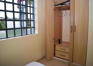 ナクルにあるFaisha 1br near Sarova Woodlands with views of lake Nakuruのベッドルーム(クローゼット、窓付)