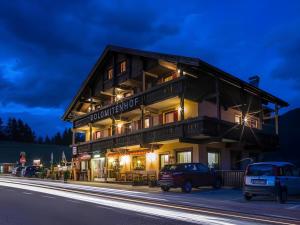 een gebouw waar auto's voor geparkeerd staan bij Dolomites Smart Holidays in Valdaora