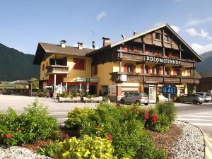 een gebouw op een straat met bloemen ervoor bij Dolomites Smart Holidays in Valdaora