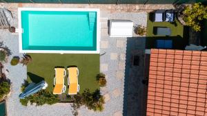 uma vista superior de uma piscina com duas cadeiras em Casas de Marvão - Casa do Ribeiro em Marvão